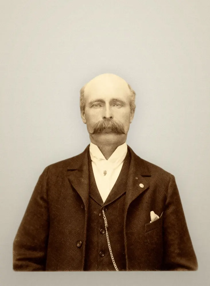 The same cabinet card restored, with the fading lifted and a plain studio background. The face is unchanged.